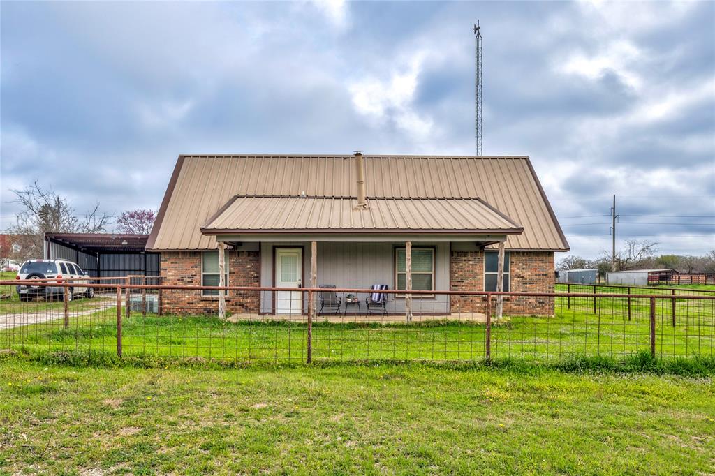 1106 HCR 1414 Covington, TX 76636 - Photo 1 of 37 a front view of a house with a yard table and chairs