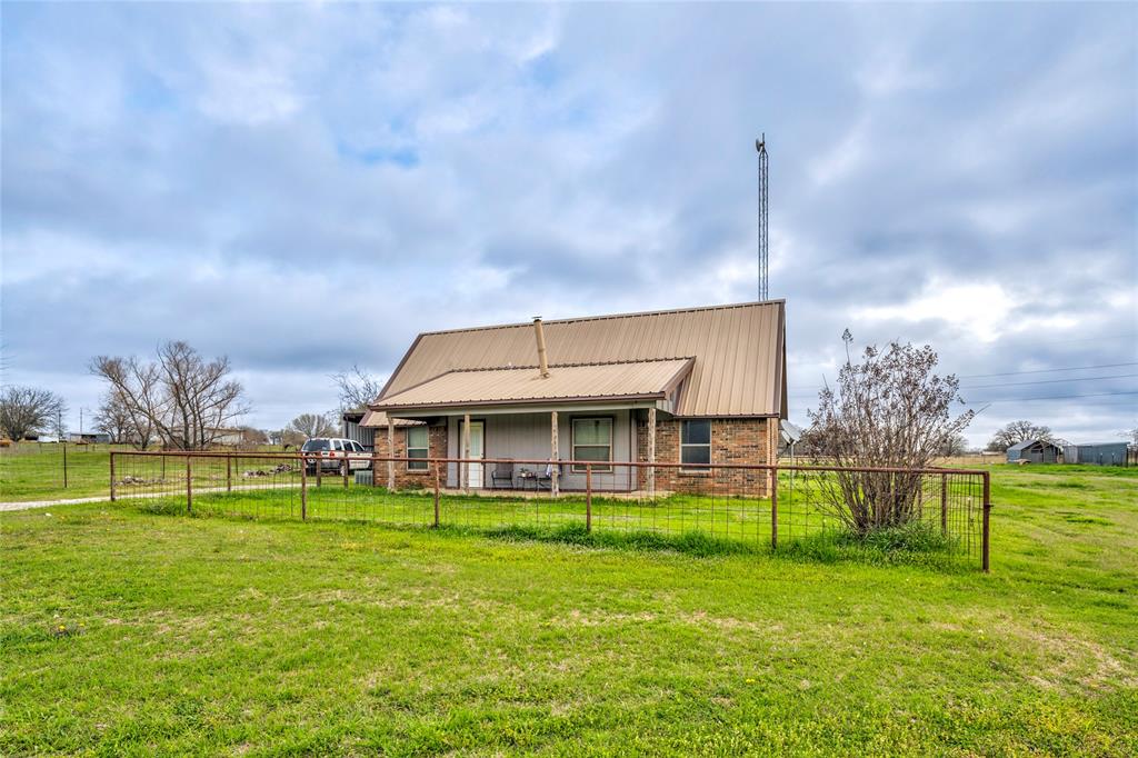 1106 HCR 1414 Covington, TX 76636 - Photo 3 of 37 a view of a house with a big yard and a large pool with table and chairs a fire pit