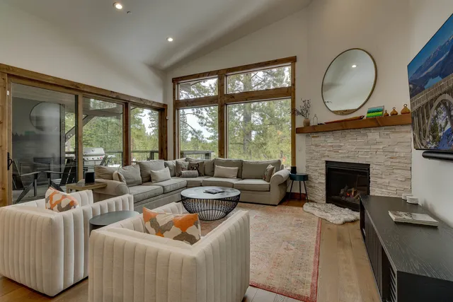 a living room with furniture fireplace and a large window