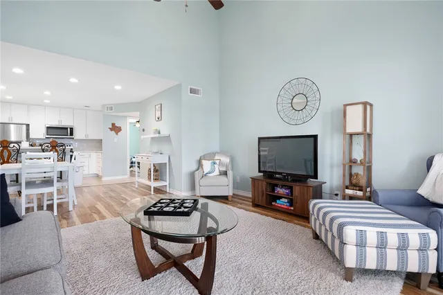 a living room with furniture a flat screen tv and kitchen view