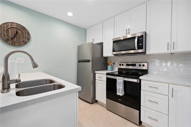 a kitchen with stainless steel appliances granite countertop a sink a stove a microwave and cabinets