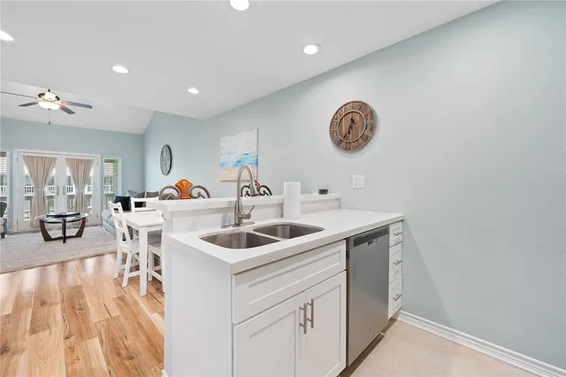 a kitchen with a sink and a stove with wooden floor