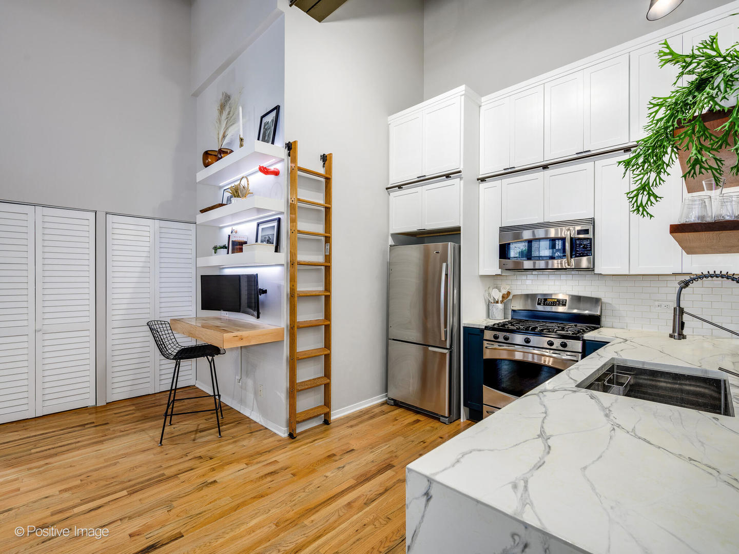 203 South Sangamon Street, Unit 216 Chicago, IL 60607 - Photo 11 of 22 a kitchen with stainless steel appliances kitchen island a table chairs in it and wooden floors