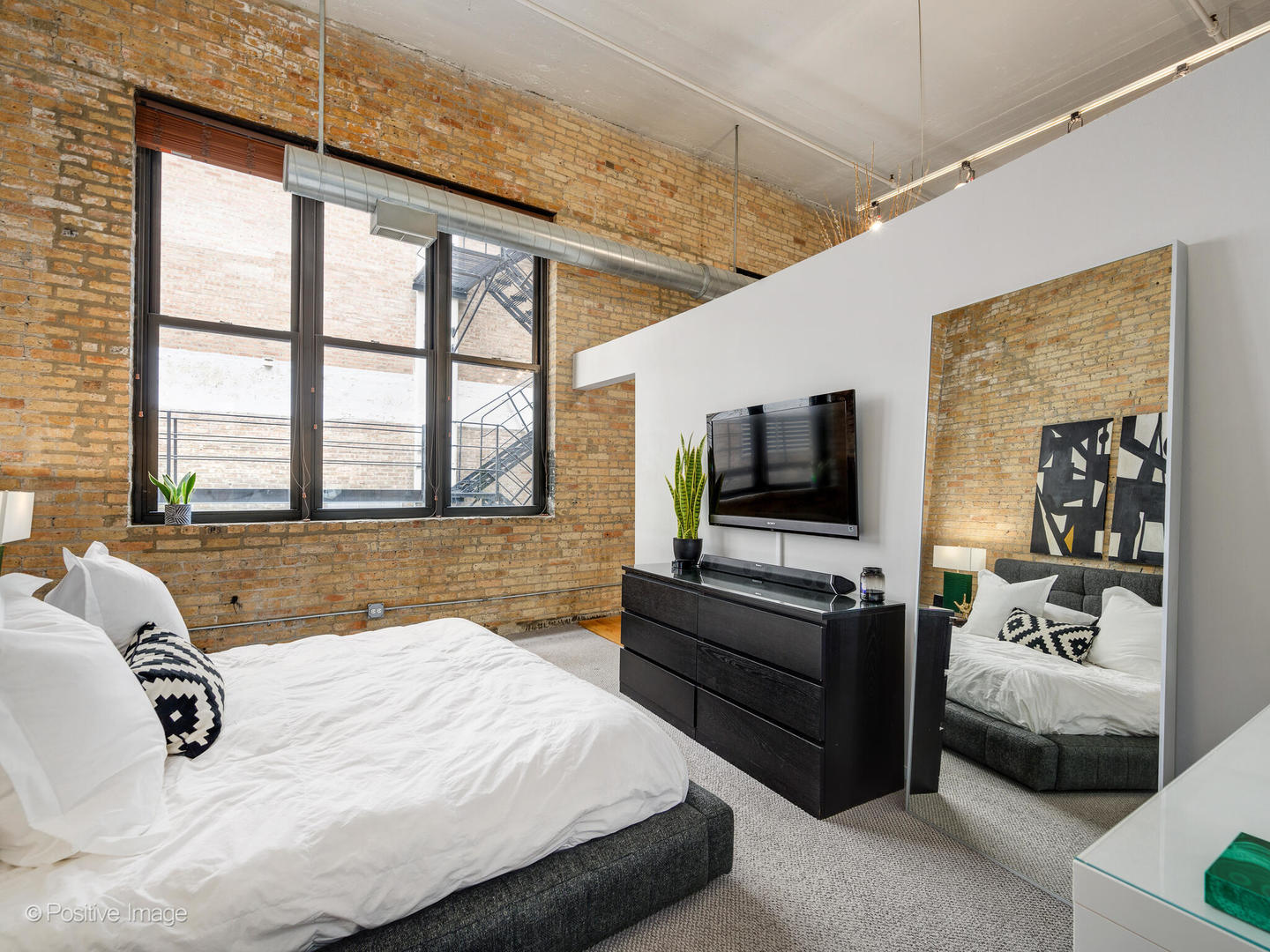 203 South Sangamon Street, Unit 216 Chicago, IL 60607 - Photo 15 of 22 a bedroom with a bed and flat screen tv