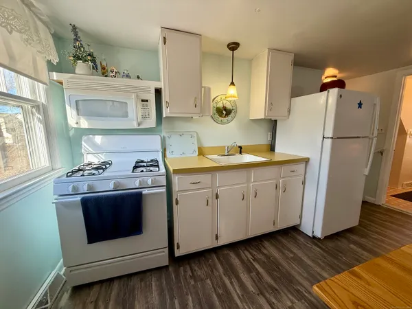 a kitchen with cabinets appliances and wooden floor