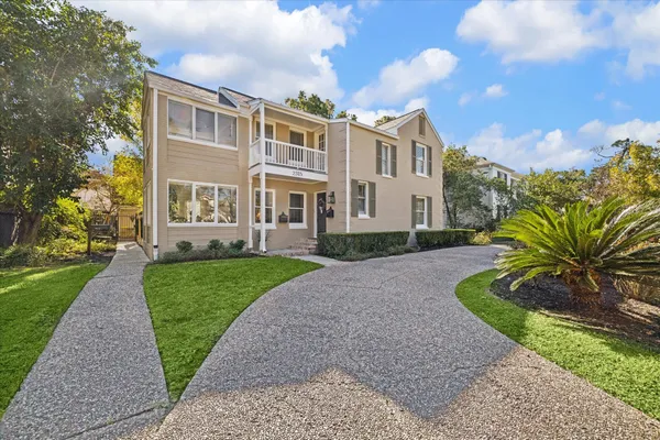a front view of a house with a garden and trees