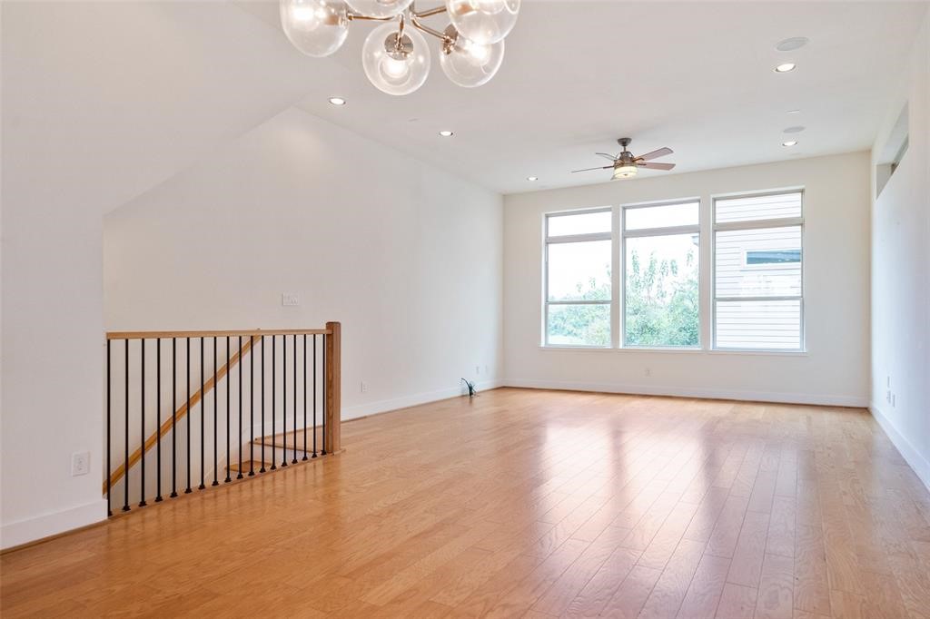 194 Harvard Street Houston, TX 77007 - Photo 13 of 43 an empty room with wooden floor and windows