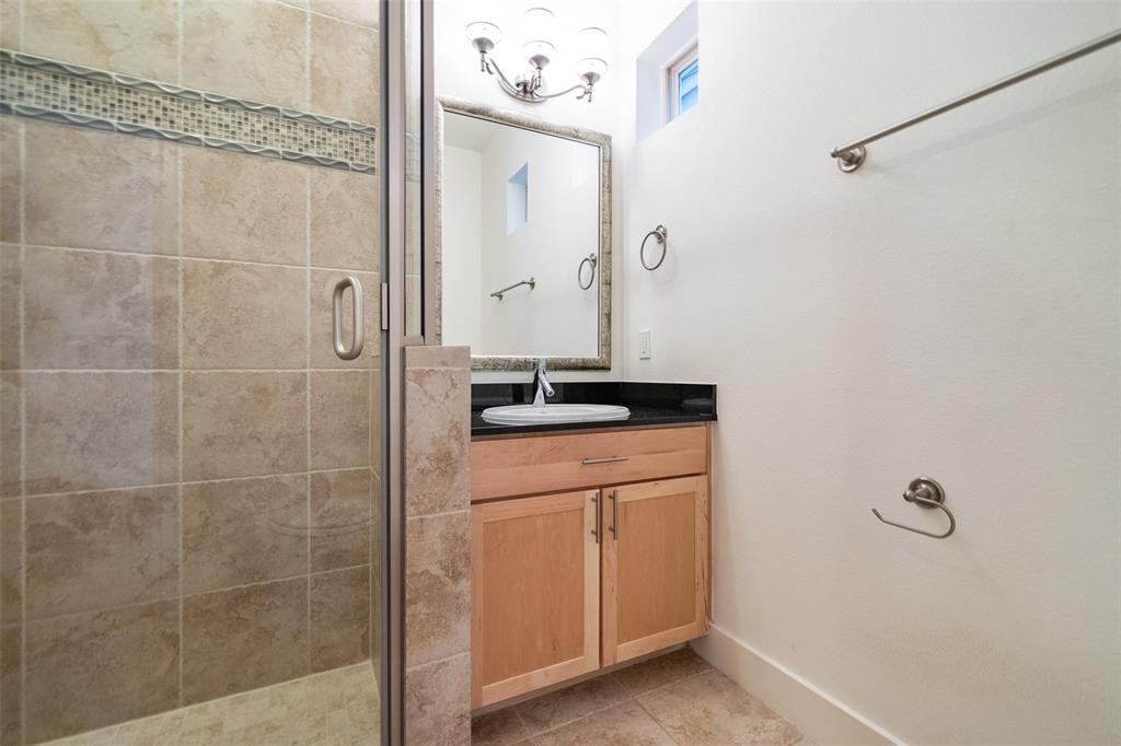 194 Harvard Street Houston, TX 77007 - Photo 6 of 43 a bathroom with a granite countertop sink a mirror and shower