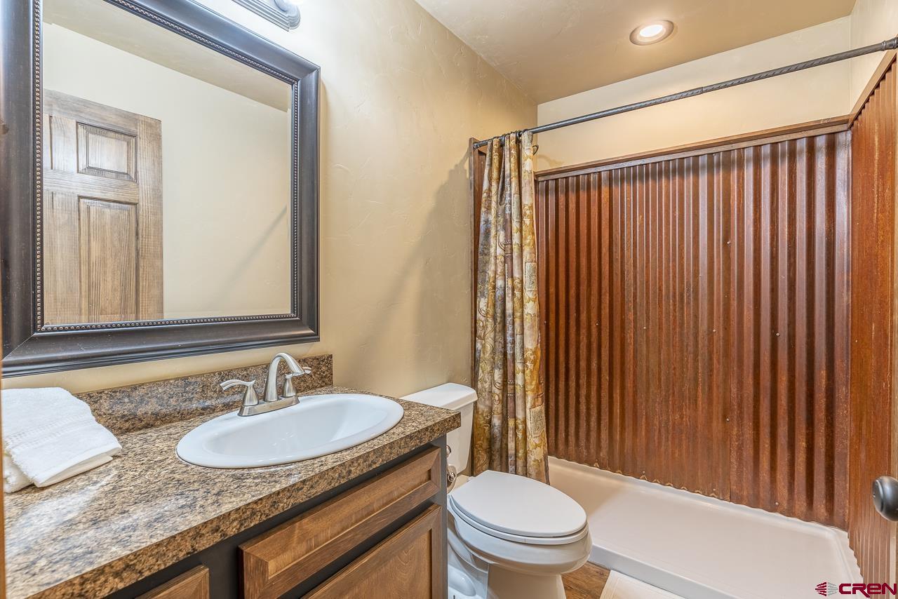 1550 Silver Mesa Driveway Durango, CO 81301 - Photo 18 of 34 a bathroom with a granite countertop sink and a mirror
