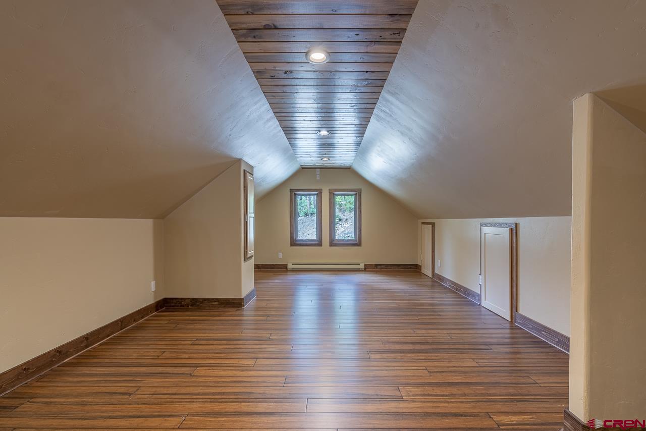 1550 Silver Mesa Driveway Durango, CO 81301 - Photo 22 of 34 a view of an empty room with wooden floor and a window
