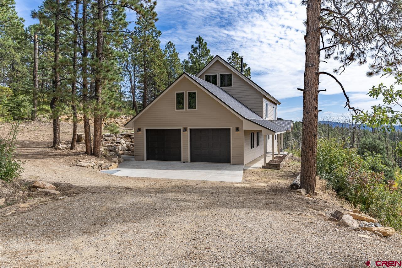 1550 Silver Mesa Driveway Durango, CO 81301 - Photo 27 of 34 a front view of a house with a yard and garage