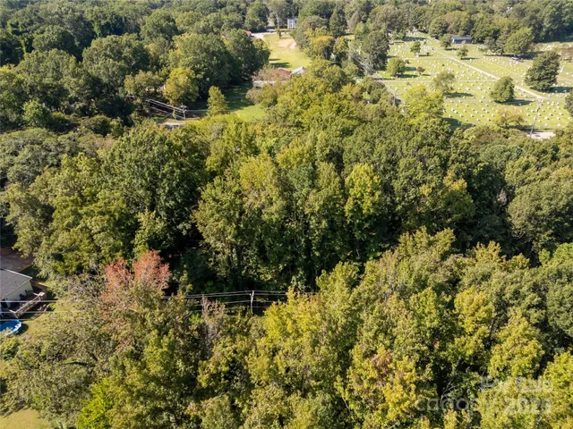 a view of a house with a lush green forest