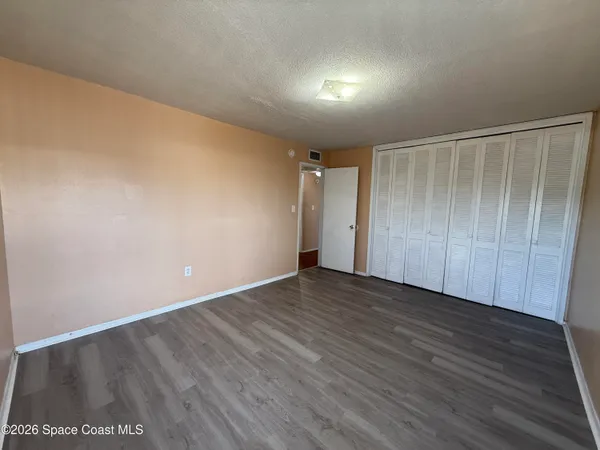 a view of an empty room with wooden floor