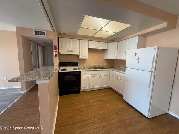 a kitchen with granite countertop a refrigerator stove and sink