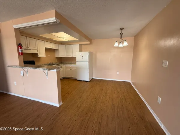 a kitchen with a sink and wooden floor