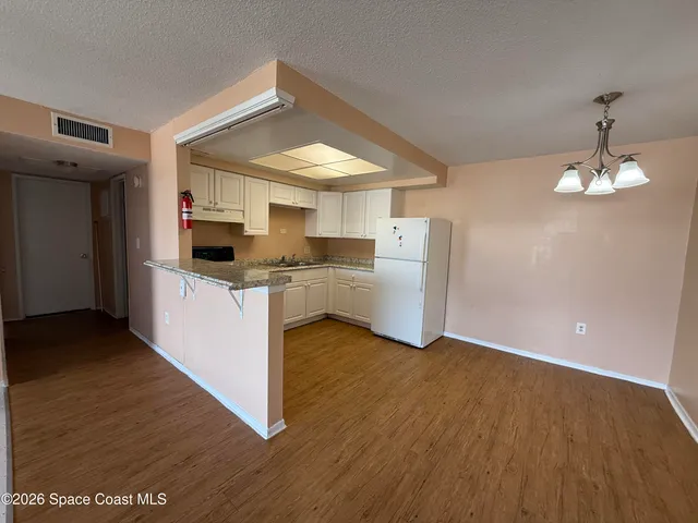 a view of a kitchen with a sink cabinets and wooden floor