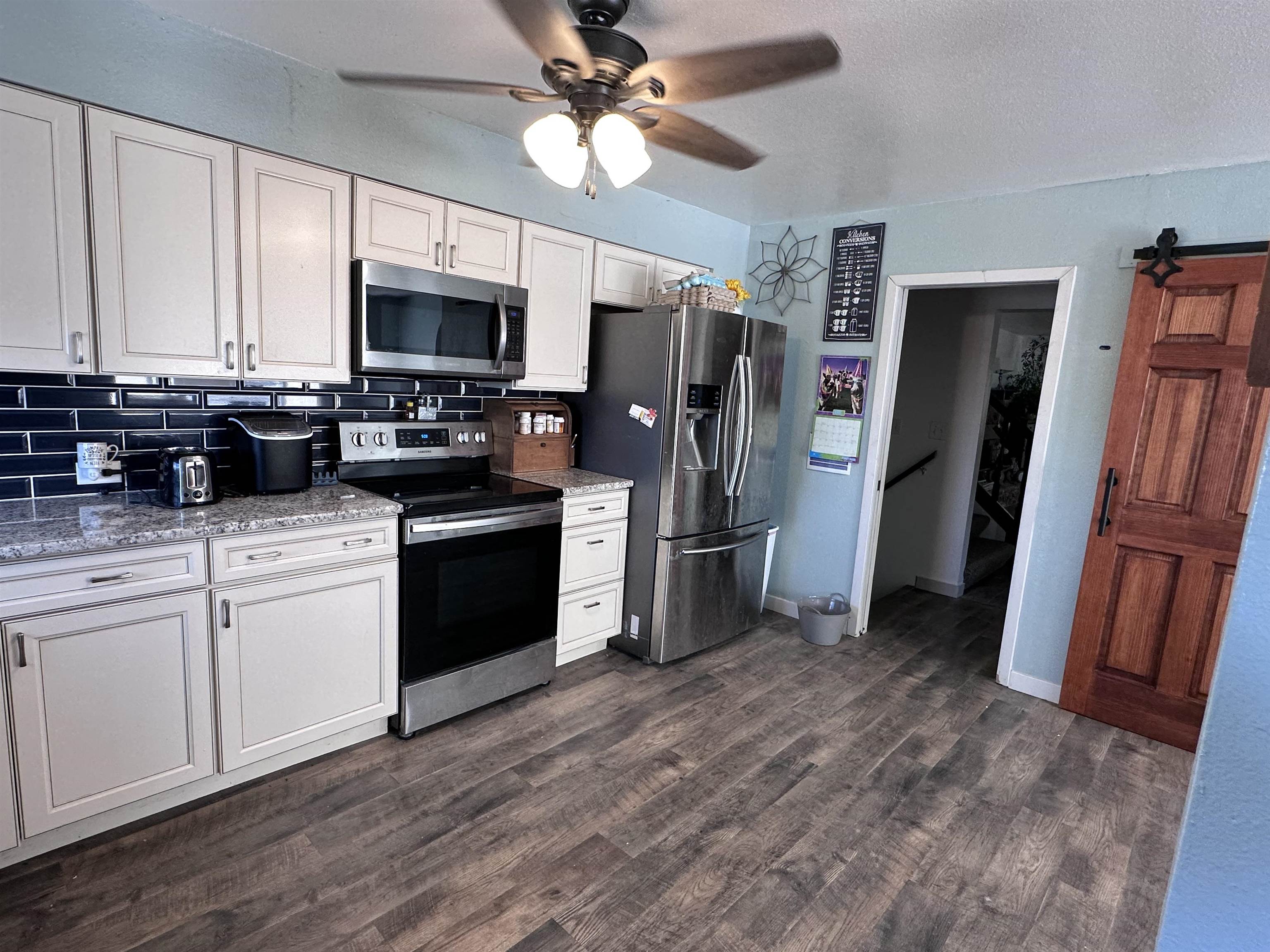 9456 6075th Road Montrose, CO 81403 - Photo 6 of 36 a kitchen with stainless steel appliances a refrigerator a stove a microwave and cabinets