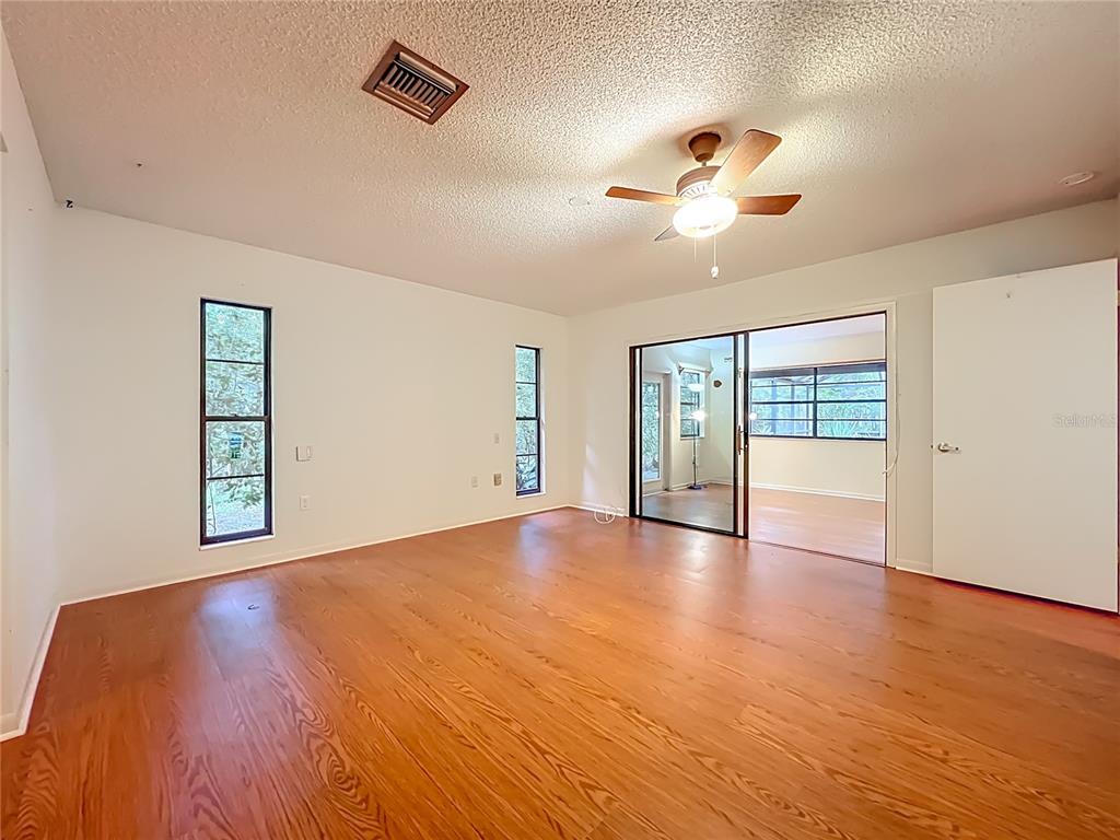 1942 Country Club Road Eustis, FL 32726 - Photo 18 of 56 a view of an empty room with a window and wooden floor