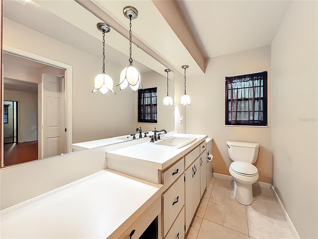 1942 Country Club Road Eustis, FL 32726 - Photo 23 of 56 a bathroom with a sink a toilet and a mirror