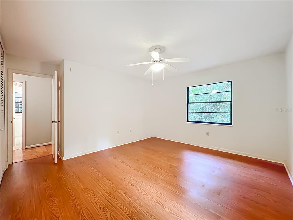 1942 Country Club Road Eustis, FL 32726 - Photo 28 of 56 an empty room with wooden floor chandelier fan and windows