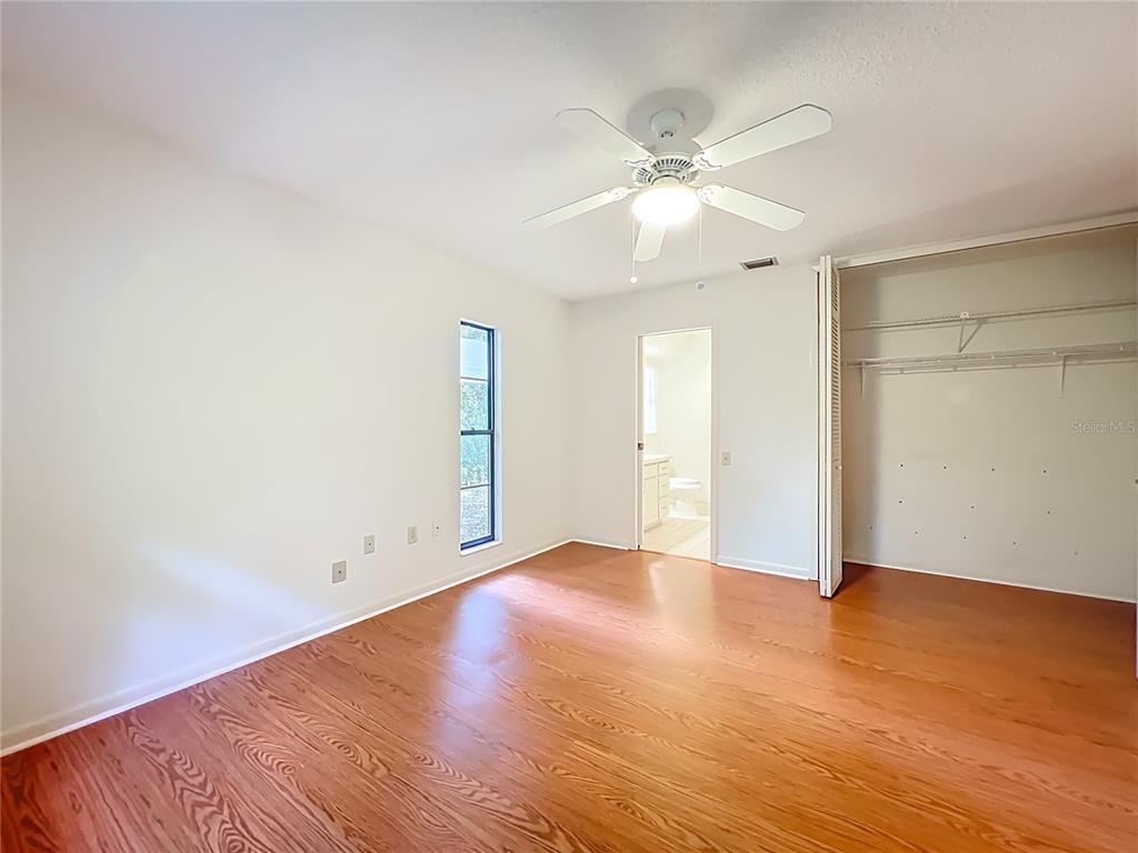 1942 Country Club Road Eustis, FL 32726 - Photo 29 of 56 an empty room with wooden floor and fan