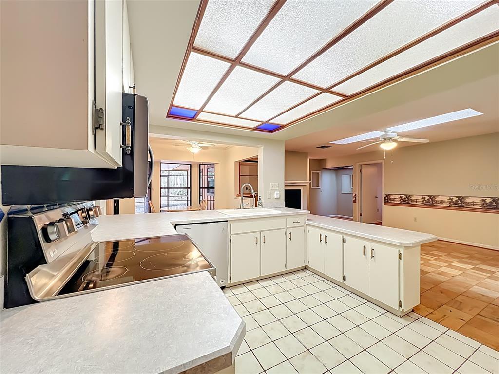 1942 Country Club Road Eustis, FL 32726 - Photo 6 of 56 a large white kitchen with a stove a sink dishwasher and wooden cabinets