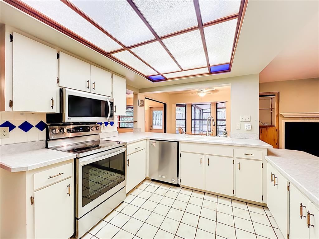 1942 Country Club Road Eustis, FL 32726 - Photo 9 of 56 a kitchen with granite countertop a stove top oven sink and cabinets