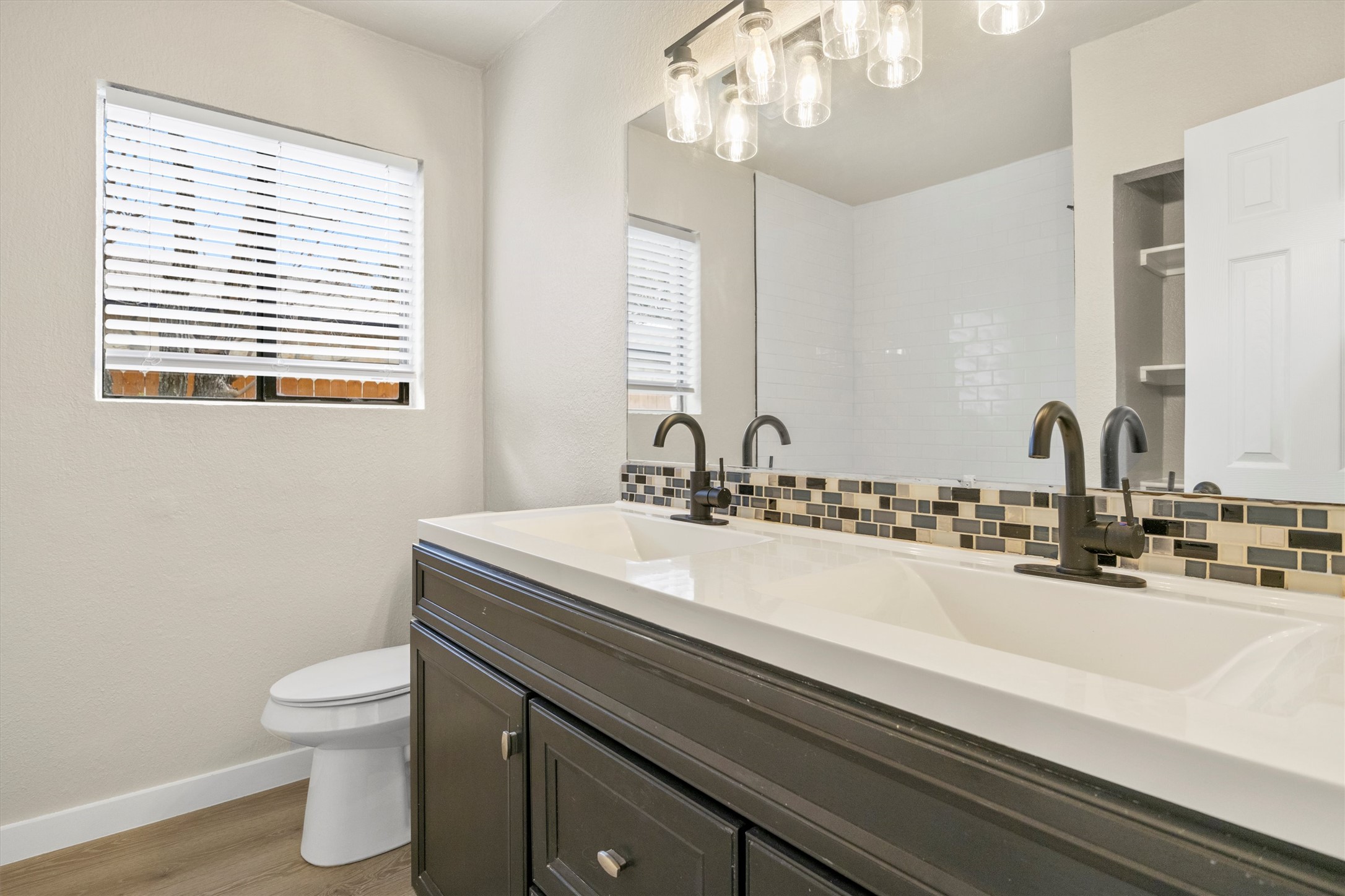 502 Pin Tail Lane Taylor, TX 76574 - Photo 12 of 26 Double vanity with dark cabinetry, white countertop, and dual integrated sinks