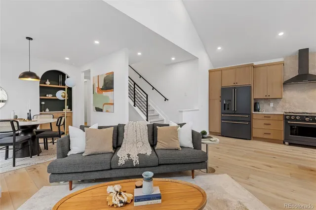 a living room with furniture wooden floor and kitchen view