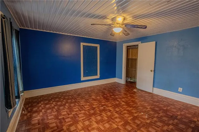 an empty room with a window and a fan
