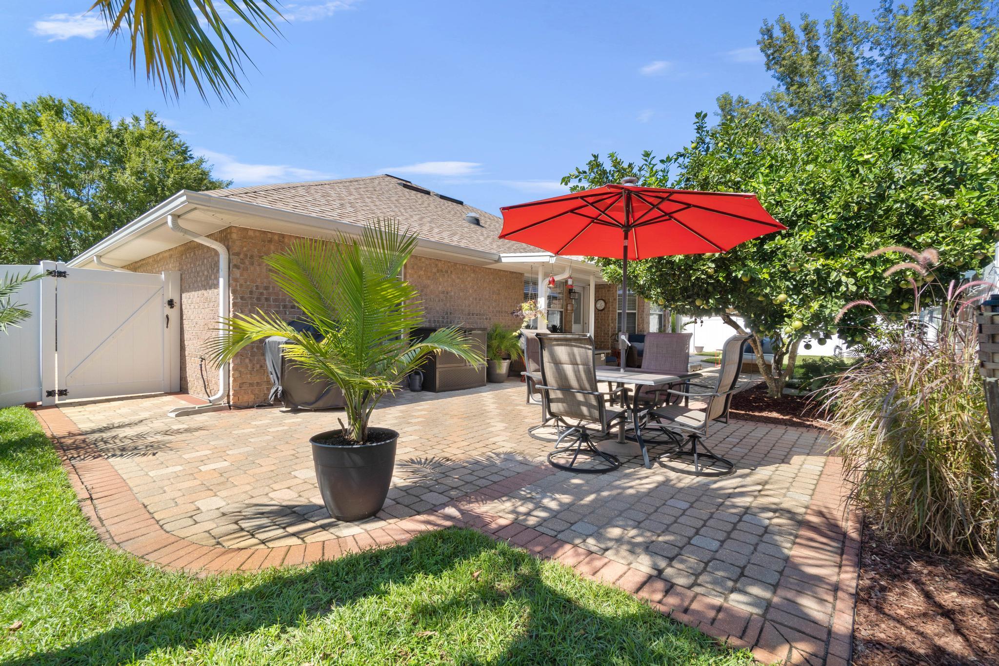99 Inlet Drive Santa Rosa Beach, FL 32459 - Photo 47 of 52 a view of a backyard with table and chairs under an umbrella