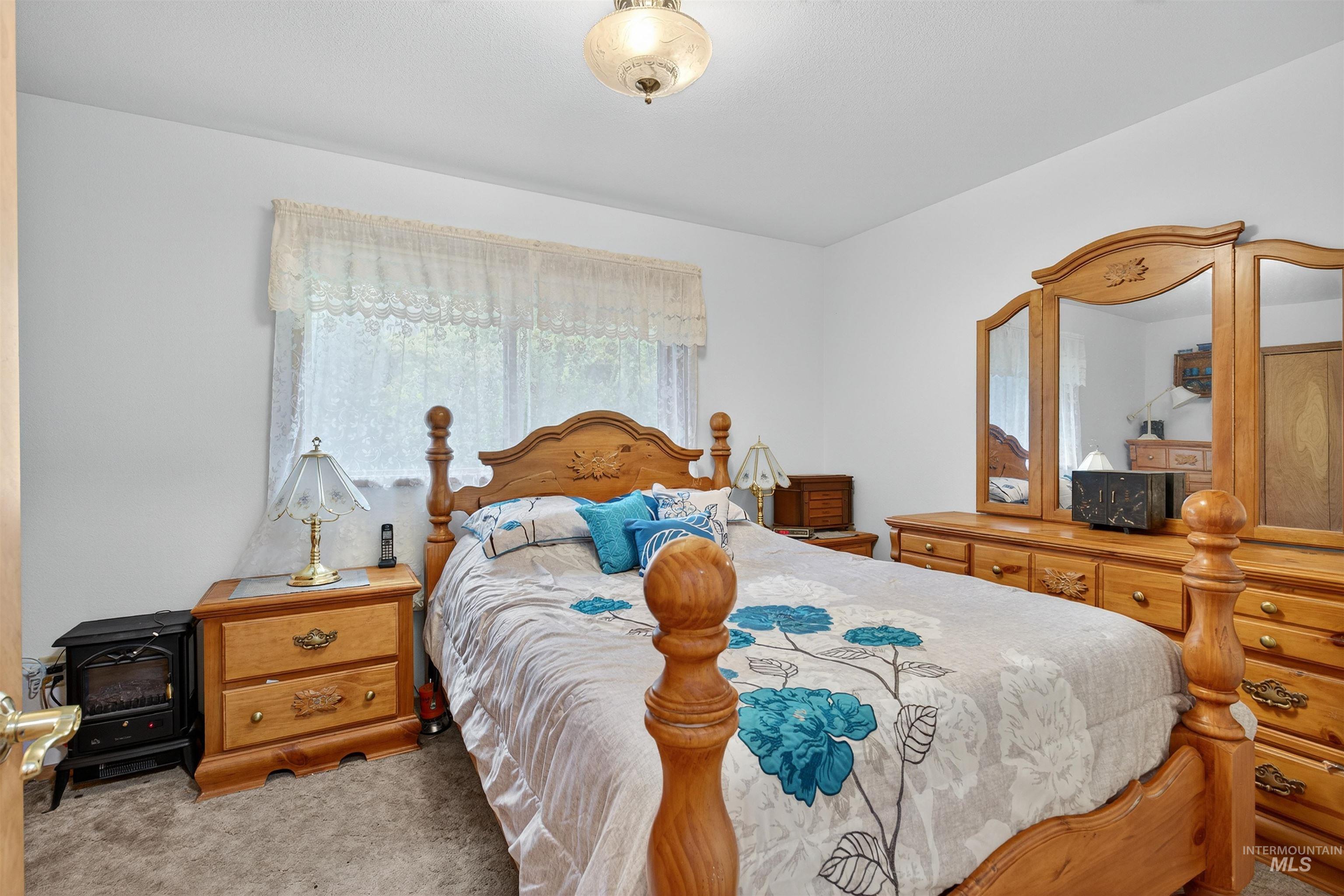 8385 Asotin Creek Road Asotin, WA 99402 - Photo 20 of 46 Bedroom with a wood stove and carpet floors