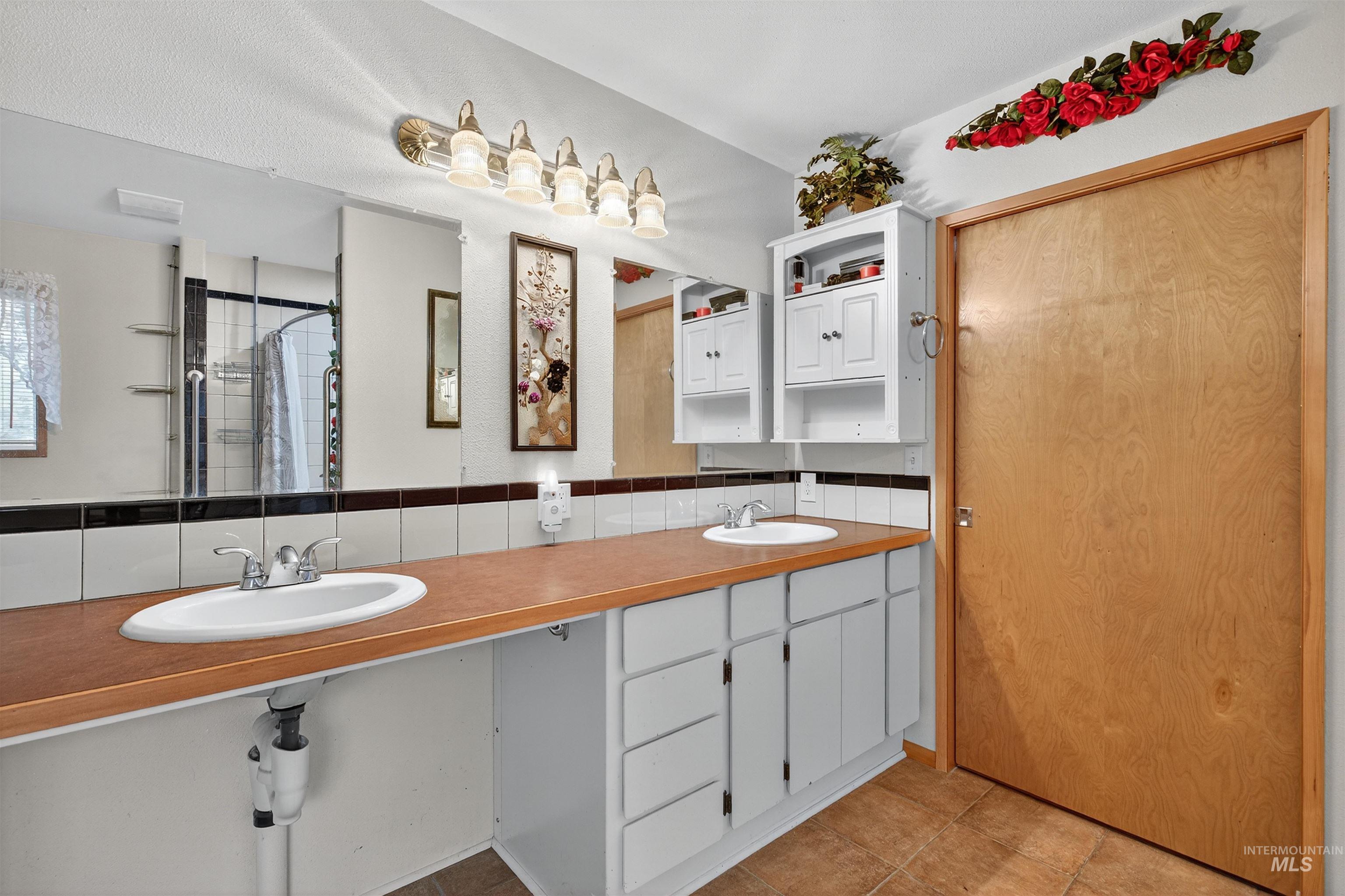 8385 Asotin Creek Road Asotin, WA 99402 - Photo 32 of 46 Bathroom with a tile shower, light tile patterned flooring, and double vanity