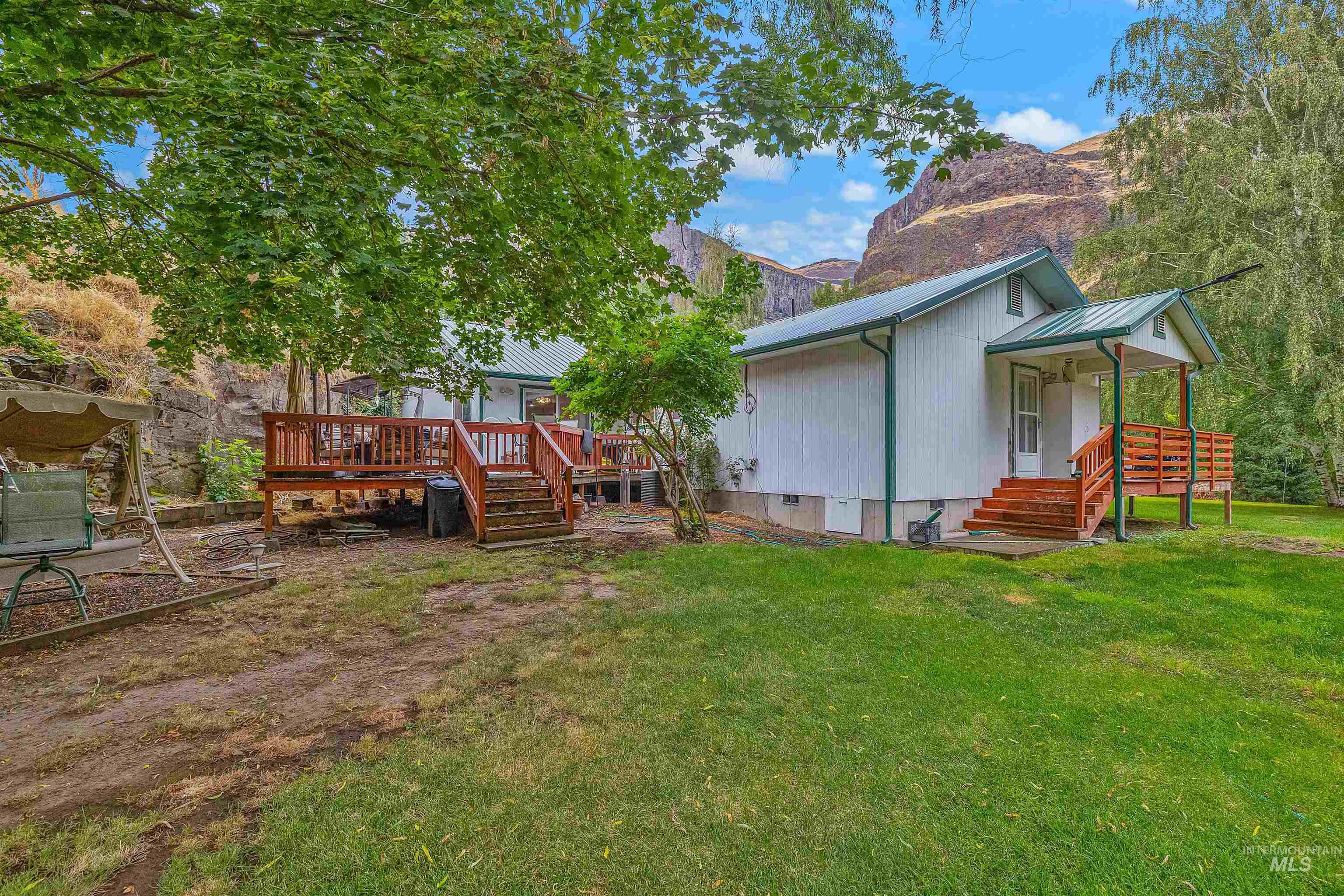 8385 Asotin Creek Road Asotin, WA 99402 - Photo 34 of 46 Back of property with a metal roof, a lawn, crawl space, stairs, and a deck with mountain view