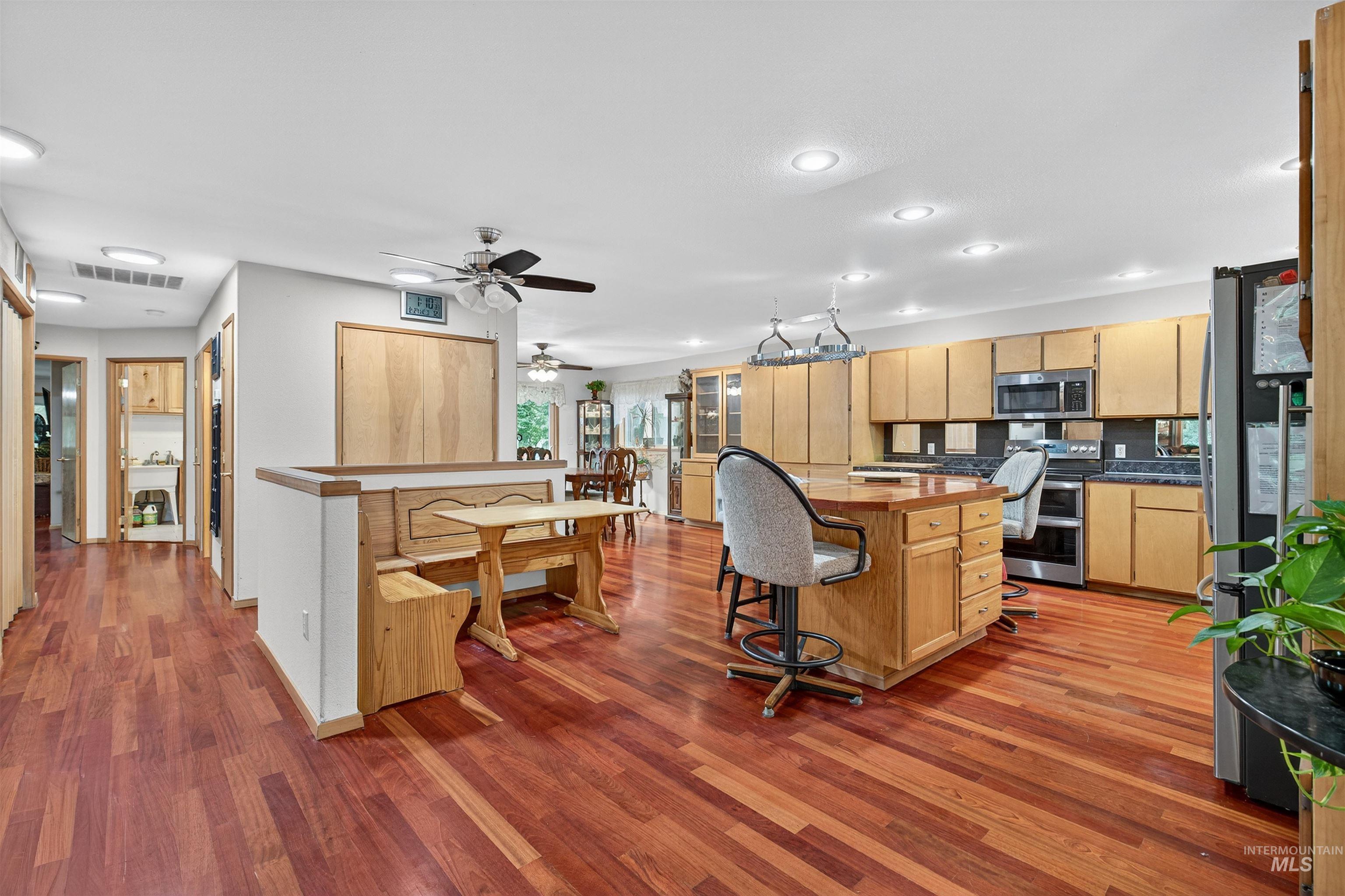 8385 Asotin Creek Road Asotin, WA 99402 - Photo 8 of 46 Kitchen featuring a breakfast bar area, dark wood-style floors, dark countertops, stainless steel appliances, and backsplash