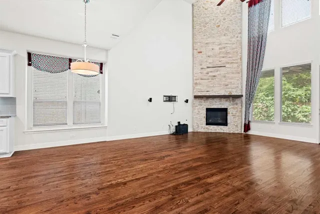 a view of empty room with wooden floor and fireplace