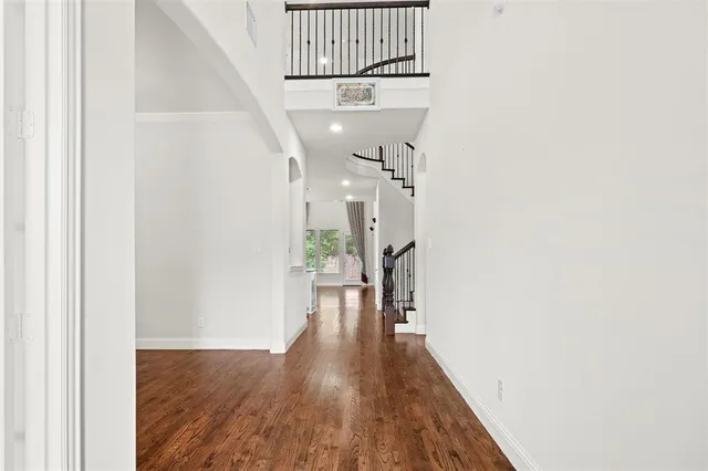 a view of a hallway with wooden floor and staircase