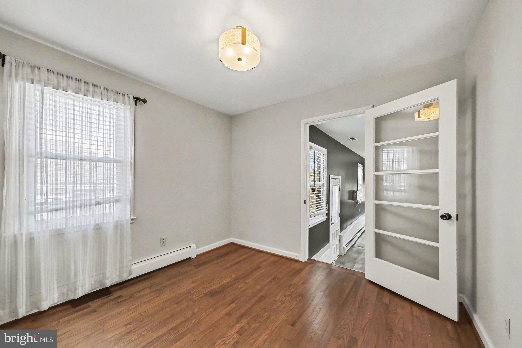 1750 Forrest Avenue Baltimore, MD 21234 - Photo 14 of 25 a view of an empty room with a window and wooden floor