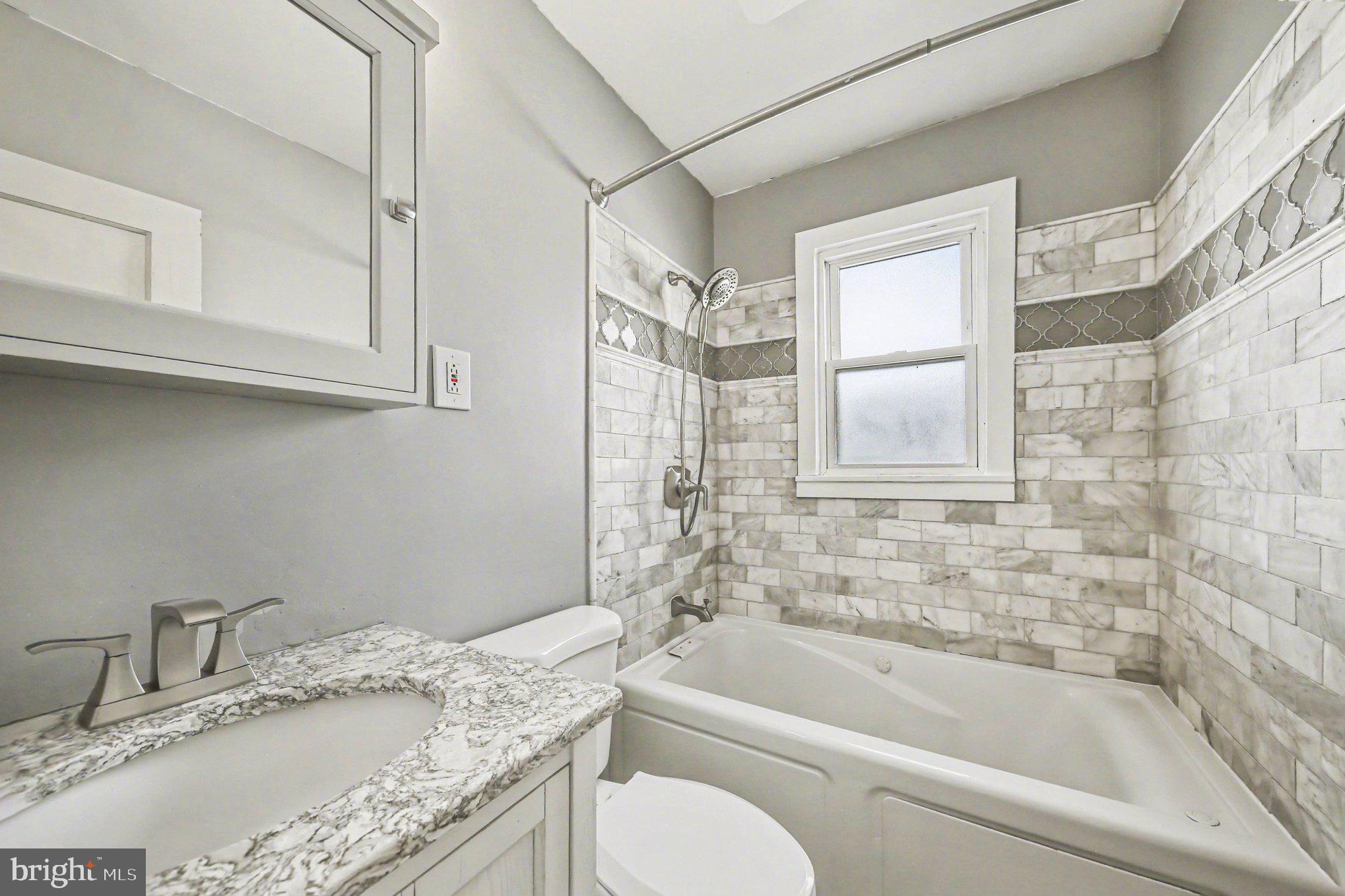 1750 Forrest Avenue Baltimore, MD 21234 - Photo 18 of 25 a bathroom with a granite countertop tub sink toilet and mirror