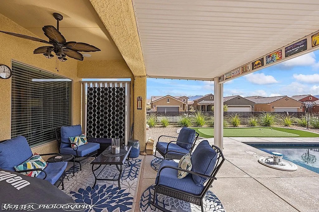 1304 Cottage Ridge Mesquite, NV 89034 - Photo 30 of 52 Enjoy outdoor living with a covered patio, ceiling fan, and refreshing poolside access.