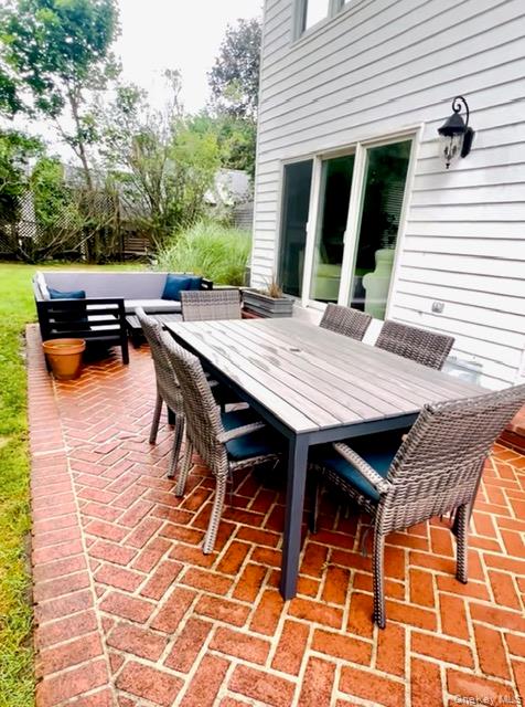25 Mitchell Road, Unit 3 Westhampton Beach, NY 11978 - Photo 17 of 18 a view of a patio with table and chairs with wooden floor and fence