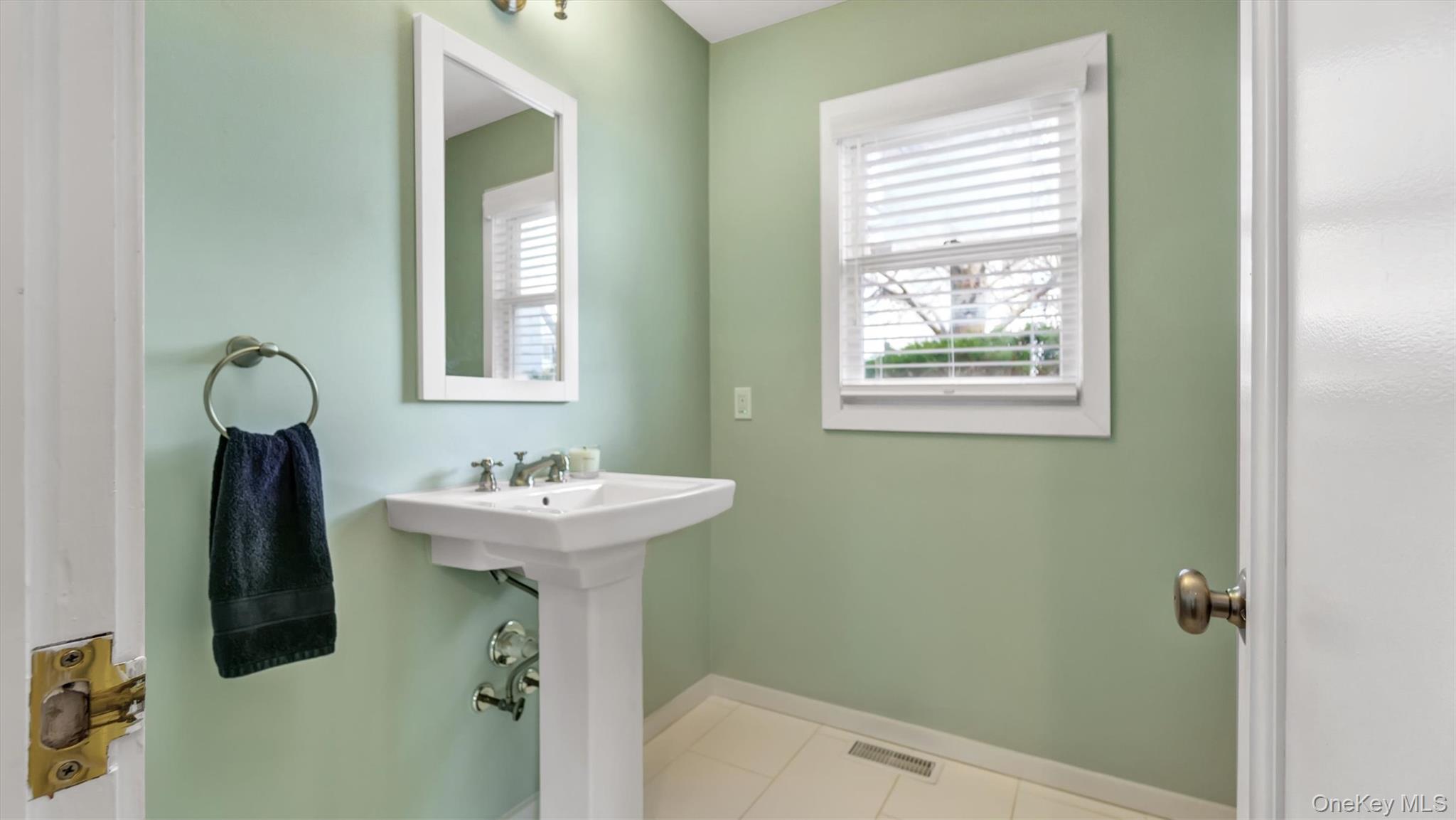 25 Mitchell Road, Unit 3 Westhampton Beach, NY 11978 - Photo 10 of 18 a bathroom with a sink a mirror and window