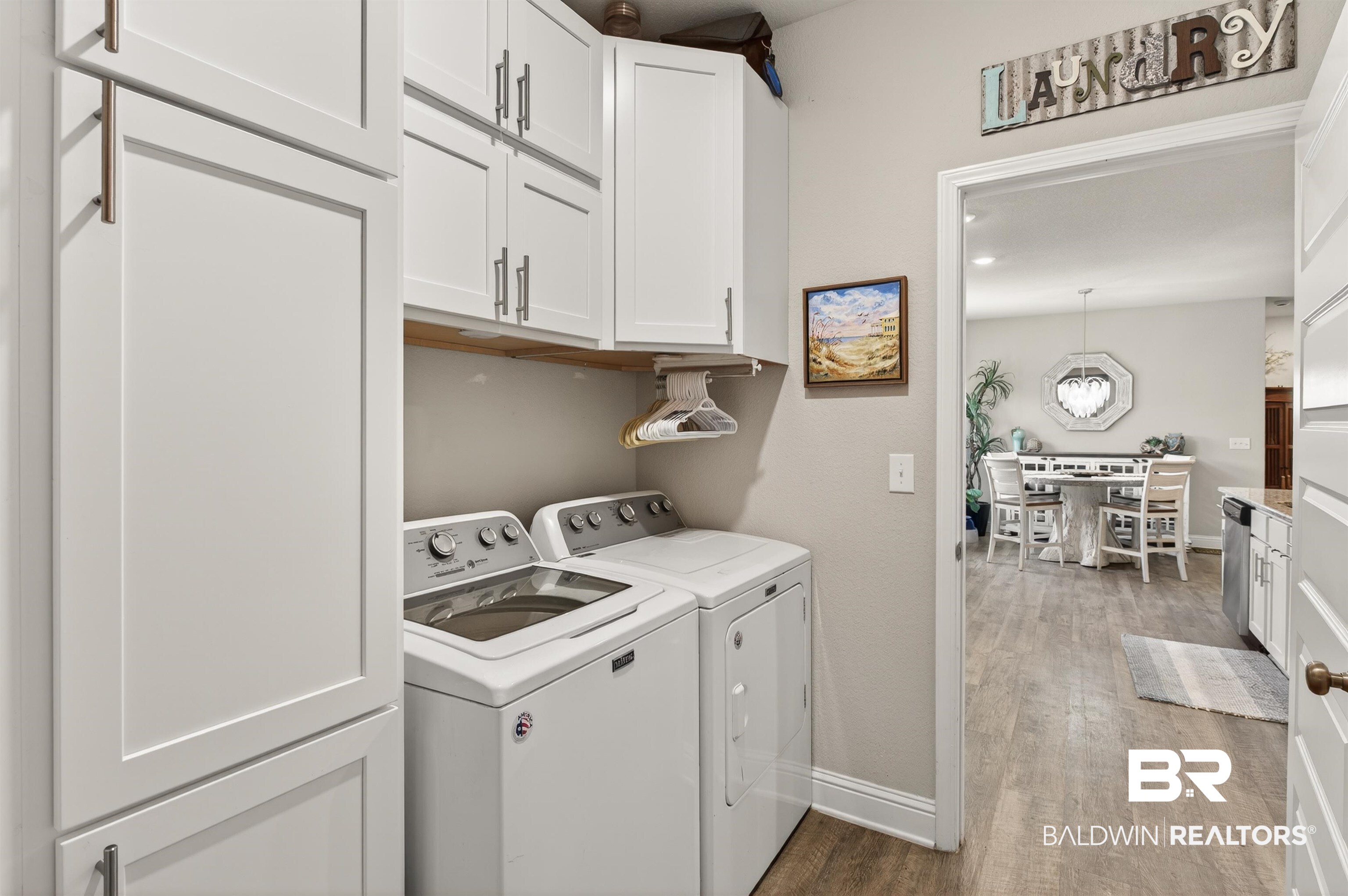 8735 Bronze Lane Foley, AL 36535 - Photo 16 of 58 Dedicated laundry area featuring a built-in storage cabinet, upper cabinetry, and a wood-finish shelf