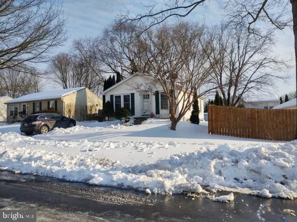 a front view of a house with a yard covered in snow