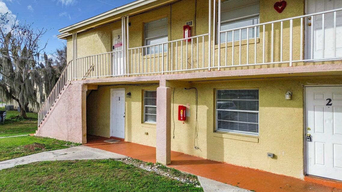 694 Michigan Court, Unit 3 St. Cloud, FL 34769 - Photo 16 of 24 a front view of a house with a yard
