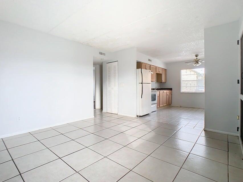 694 Michigan Court, Unit 3 St. Cloud, FL 34769 - Photo 2 of 24 a view of a kitchen with a sink and a refrigerator