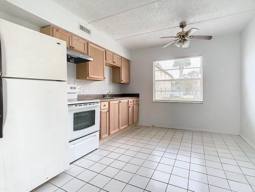 694 Michigan Court, Unit 3 St. Cloud, FL 34769 - Photo 9 of 24 a kitchen with a stove a sink and a refrigerator