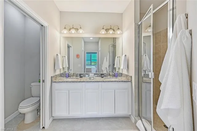 a bathroom with a granite countertop sink a toilet and a mirror