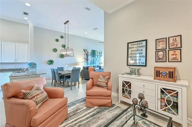 a living room with furniture kitchen view and a window