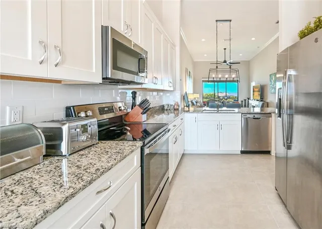 a kitchen with stainless steel appliances granite countertop a sink a stove and a refrigerator